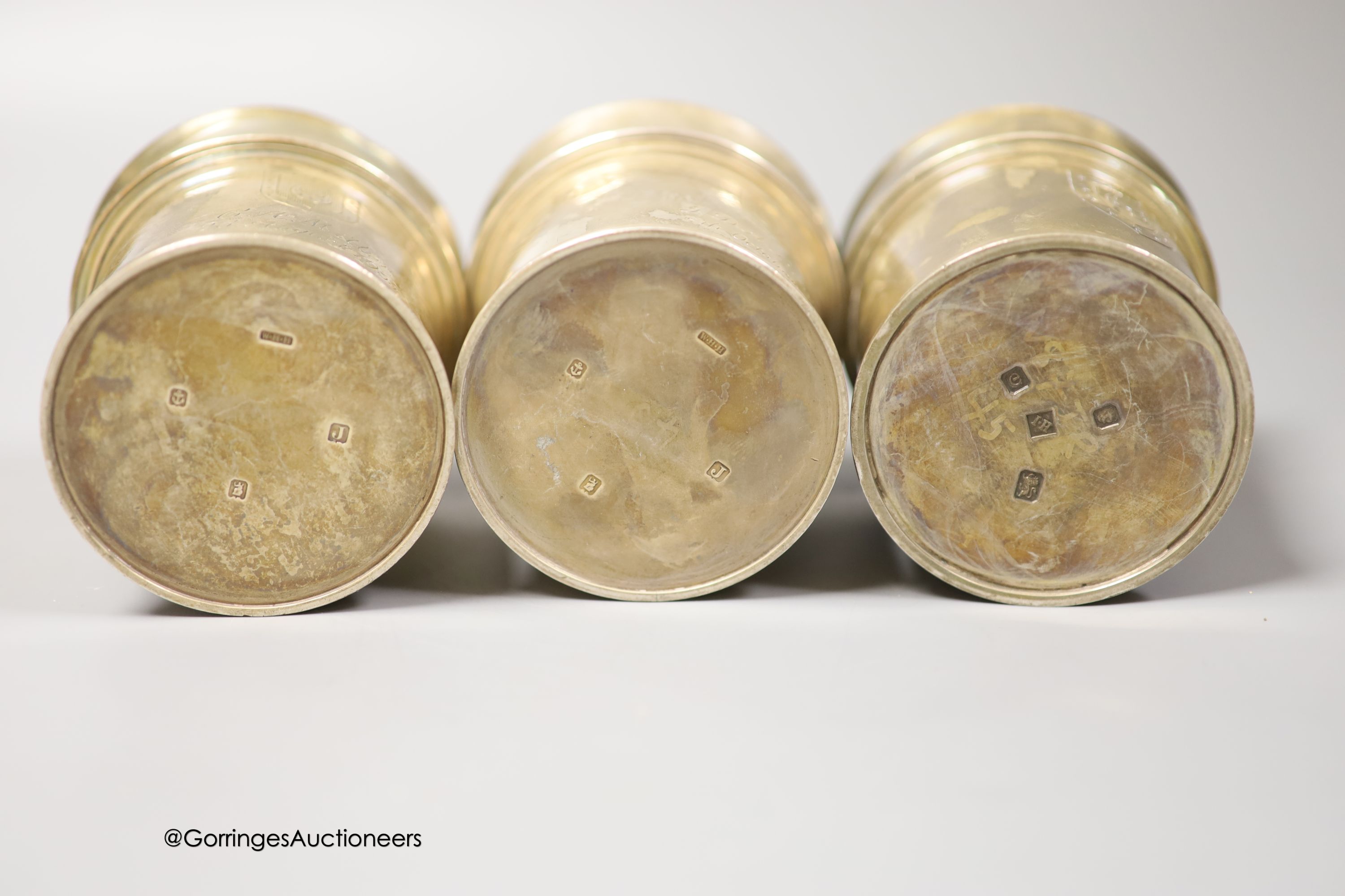 A pair of George V Brittania standard silver beakers, with engraved inscription, W. H. Haseler Ltd, Birmingham, 1933 and one other later similar beaker, How of Edinburgh Ltd, London, 1960, all 94mm, 29.5oz.